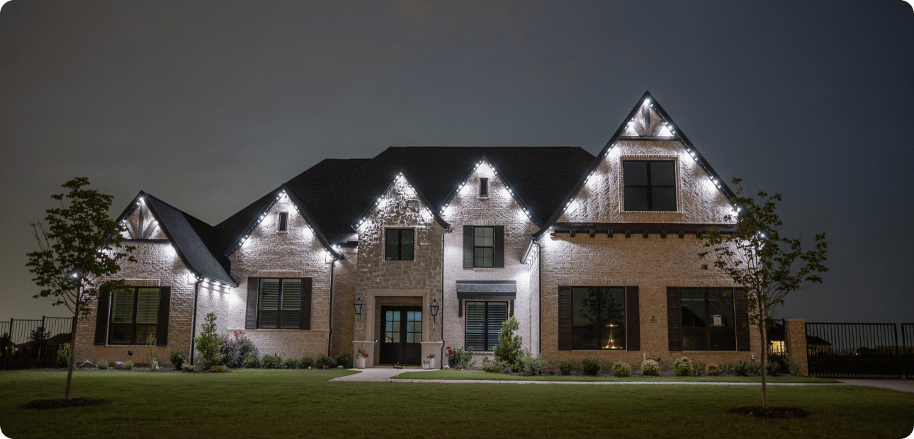 Home lit with warm white architectural accent lighting at dusk