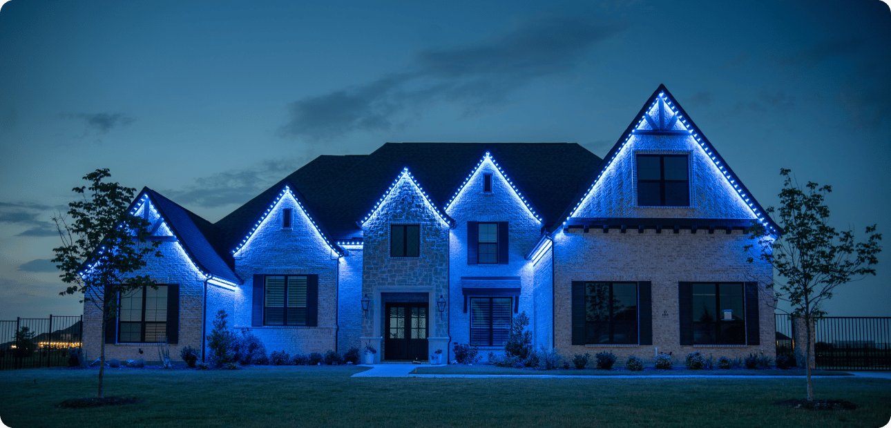 Home lit with team-color game day lighting at dusk