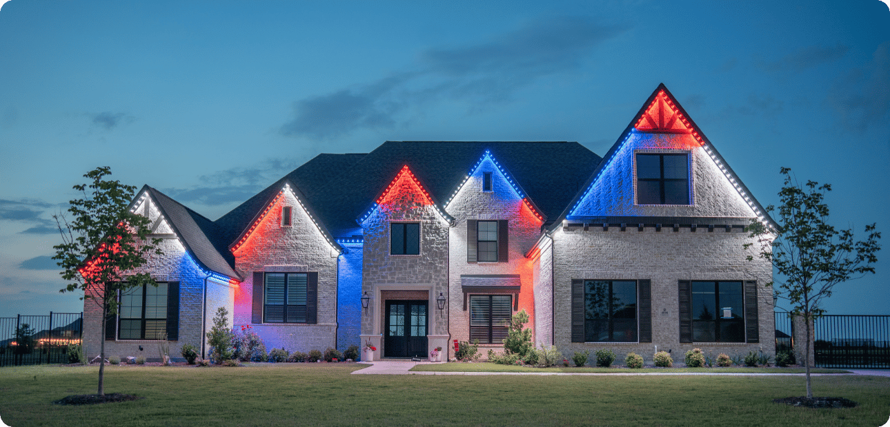 Home lit with red and green holiday lighting at dusk